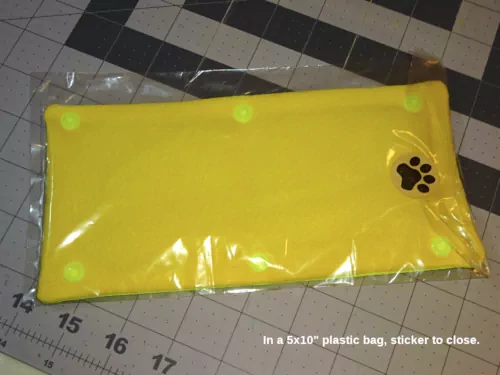 The leash sleeve in a plastic bag, closed with a paw-print sticker