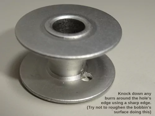 2. bobbin with hole drilled through one side (inside view)